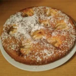 Apfelkuchen mit Puderzucker bestreut auf einem Teller