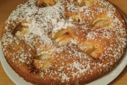 Apfelkuchen mit Puderzucker bestreut auf einem Teller