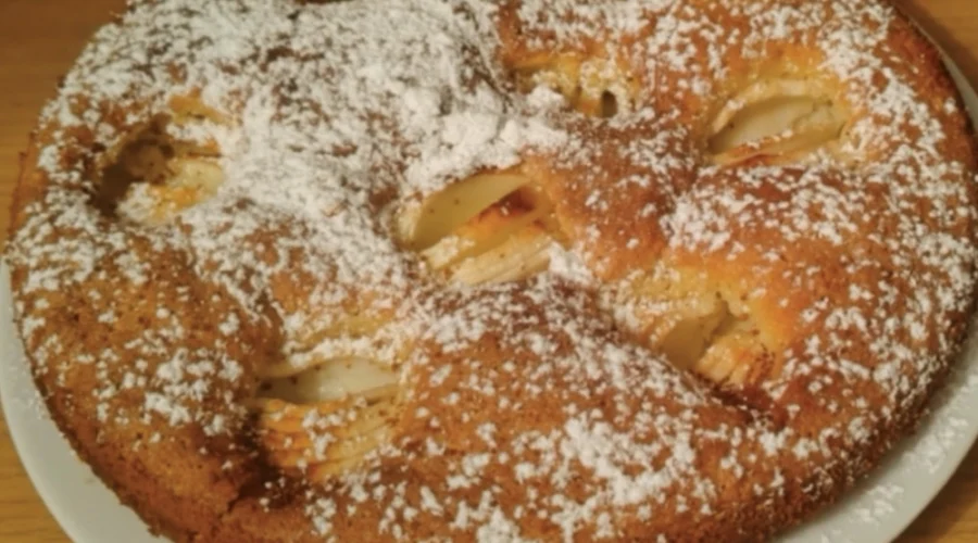 Apfelkuchen mit Puderzucker bestreut auf einem Teller